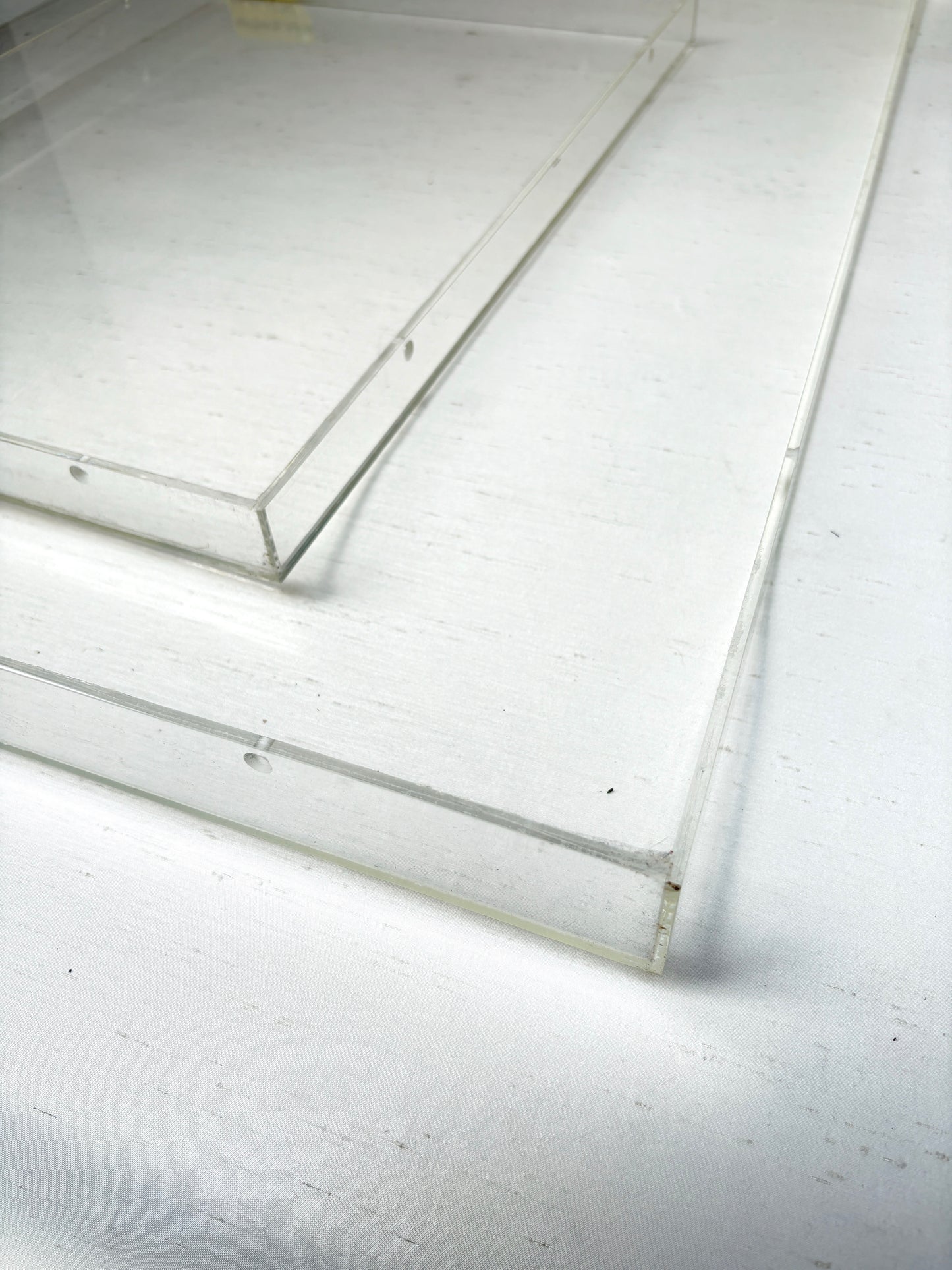 Close-up of 2 different sizes of the clear rectangular perspex frames 