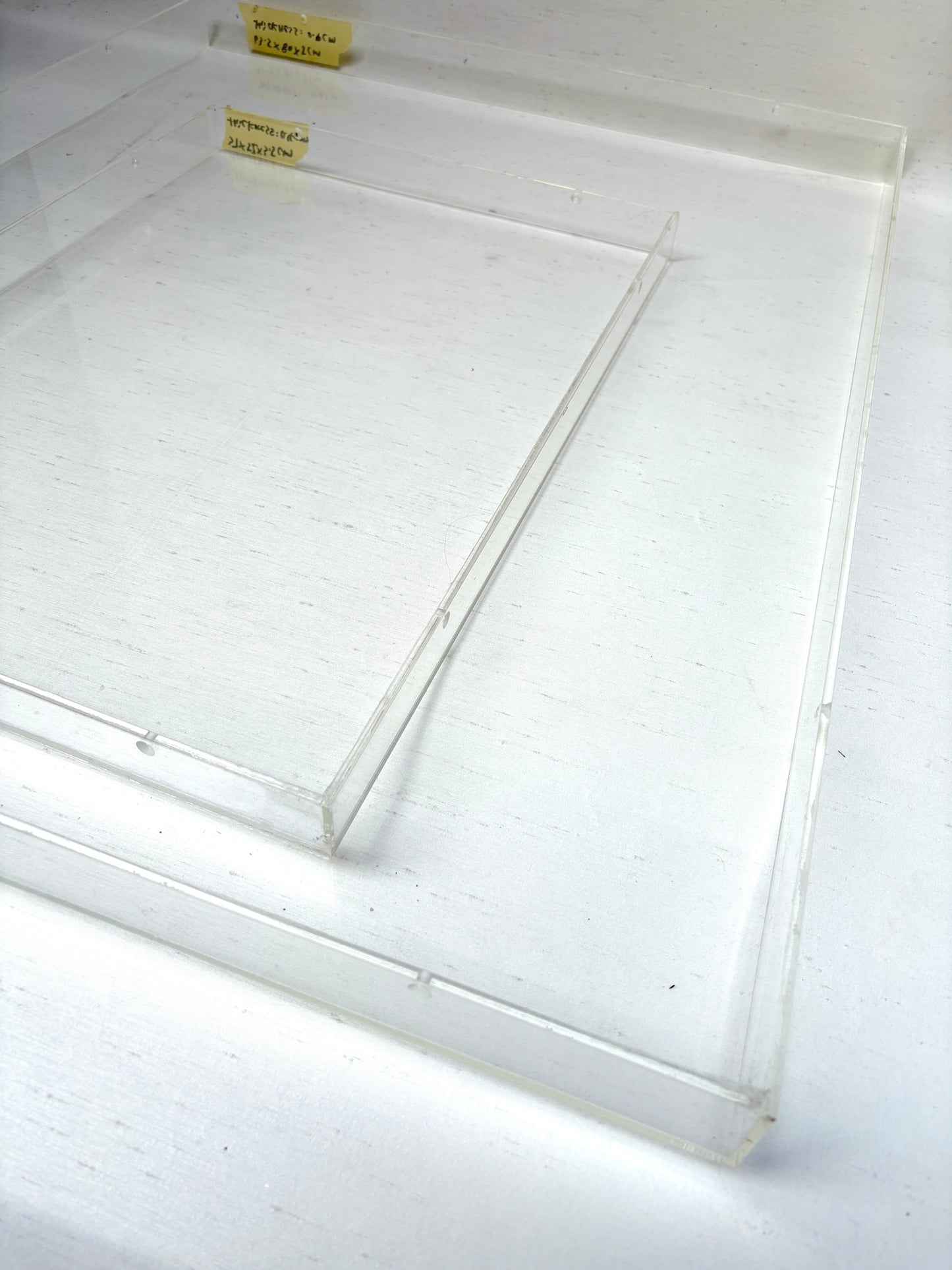 Close-up of 2 different sizes of the clear rectangular perspex frames 