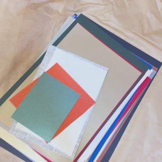 someone filming themselves going through a stack of coloured paper