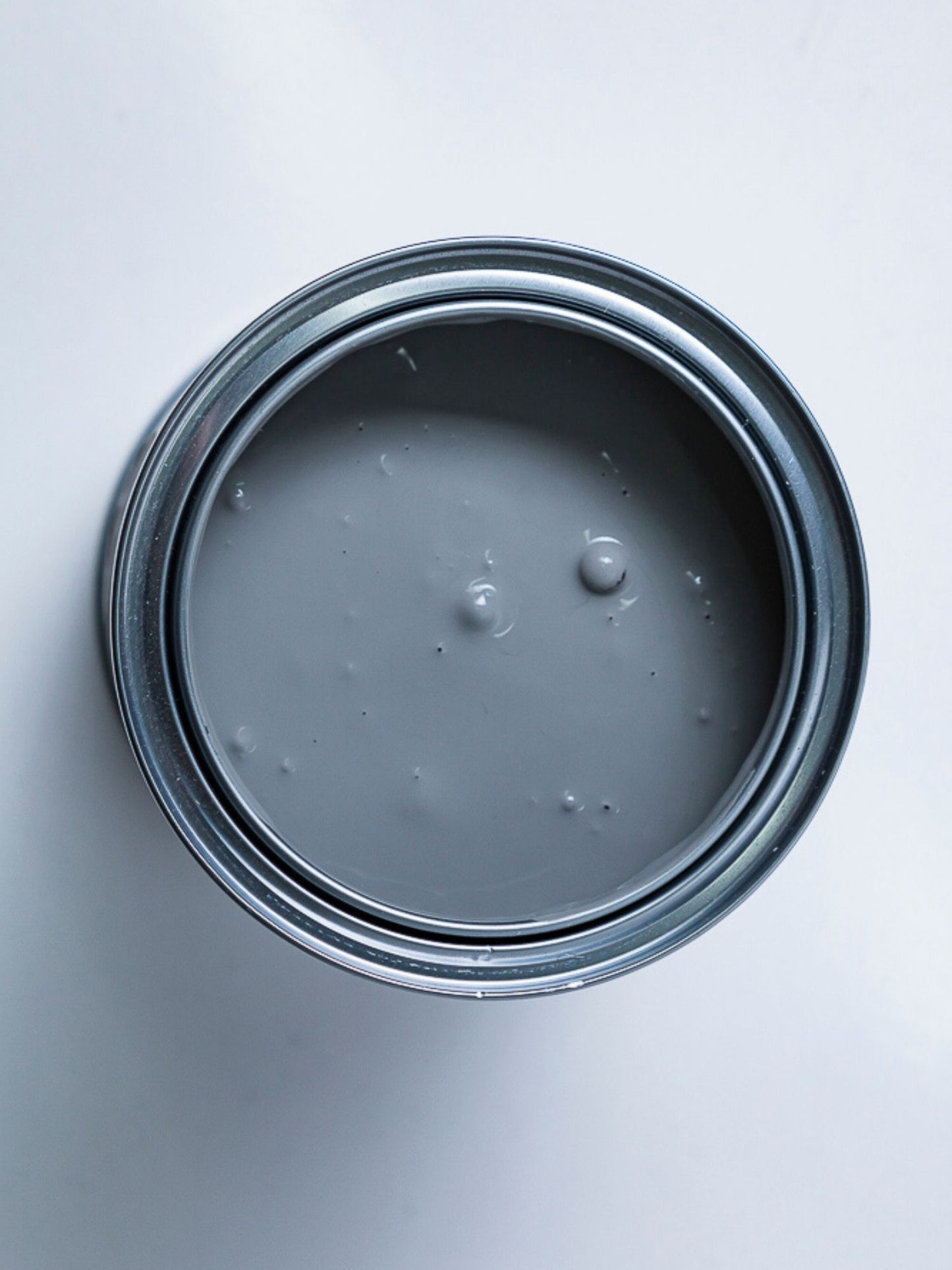 Top view of an acrylic paint can with the lid off showing a grey colour.