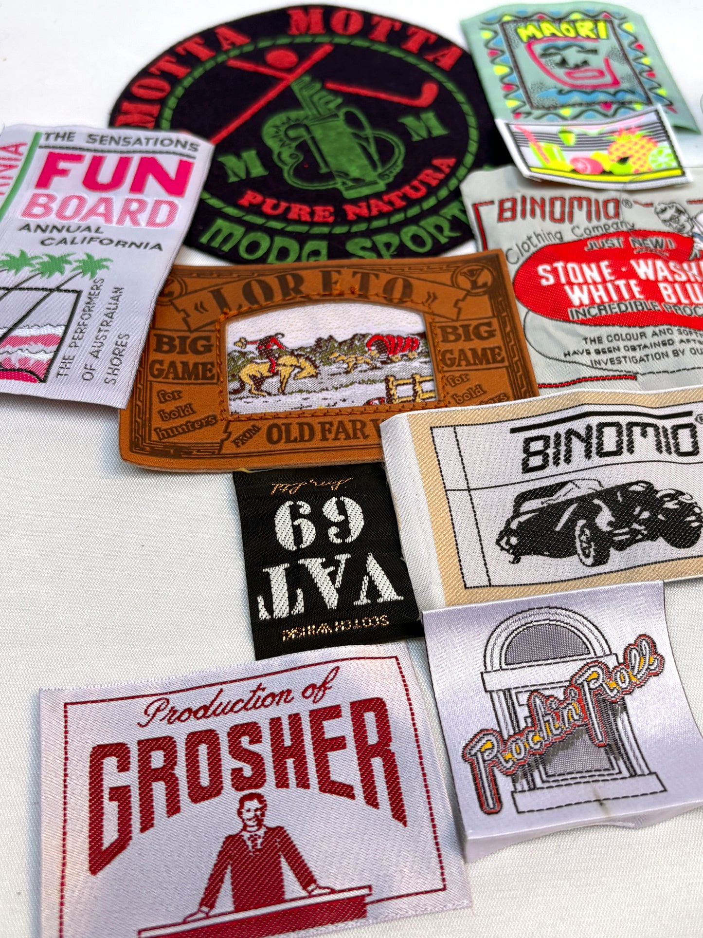 Close view of assorted woven labels and vintage-style embroidered badges.