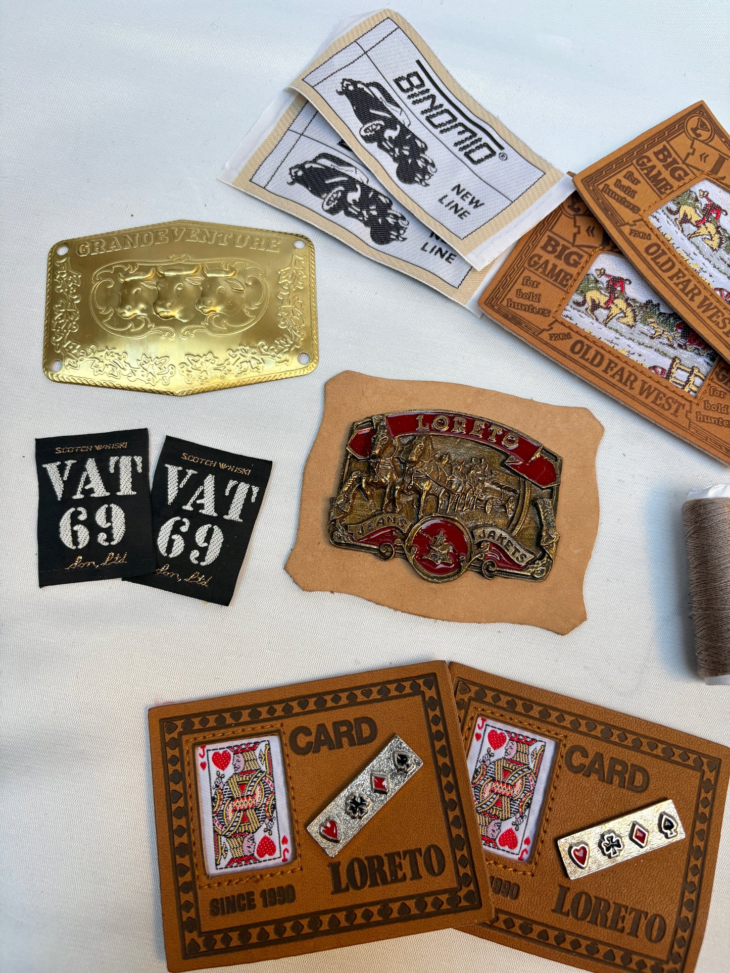Collection of belt buckles and card holders with branding on a white background