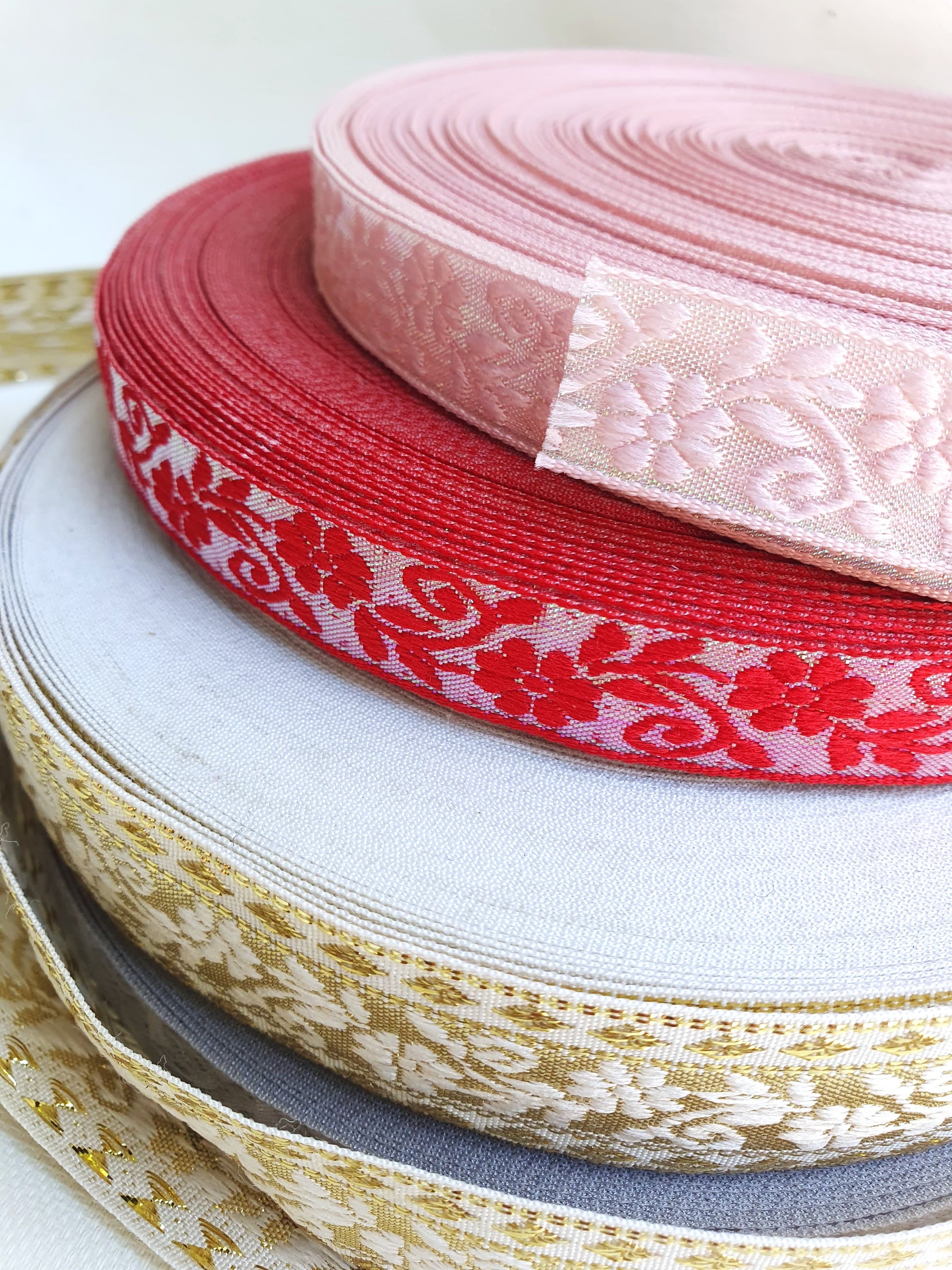 Close-up of three different colours of embroidered ribbons