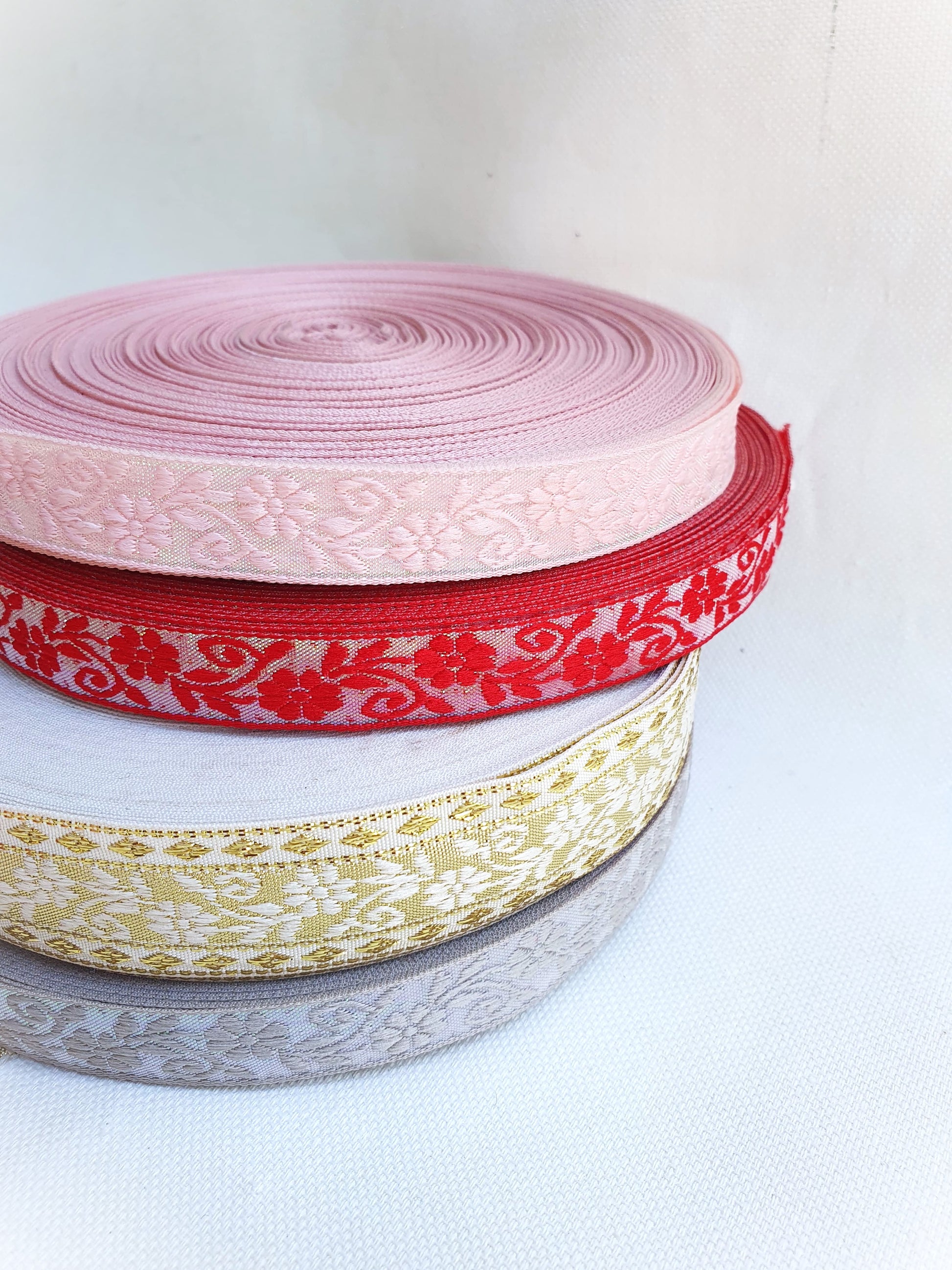 Stack of 4 different colours of floral embroidered ribbons