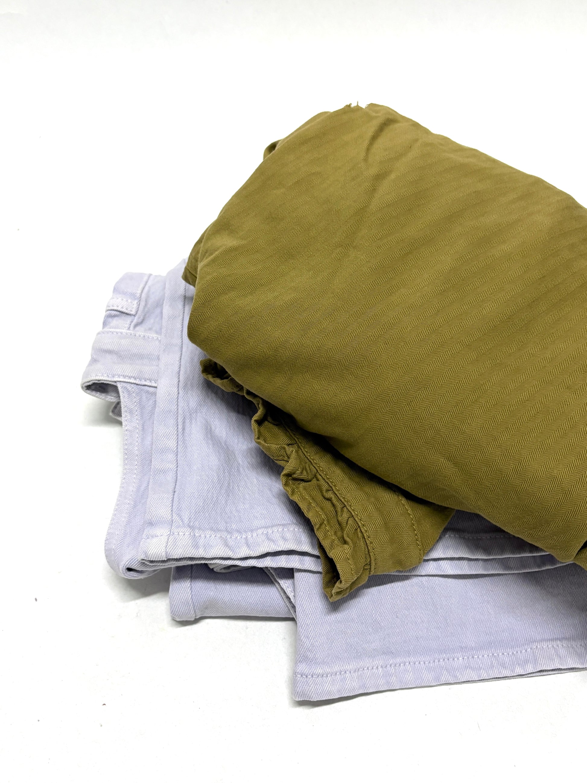 2 different types of ripped denim garments, one is moss green in colour, and the other is white