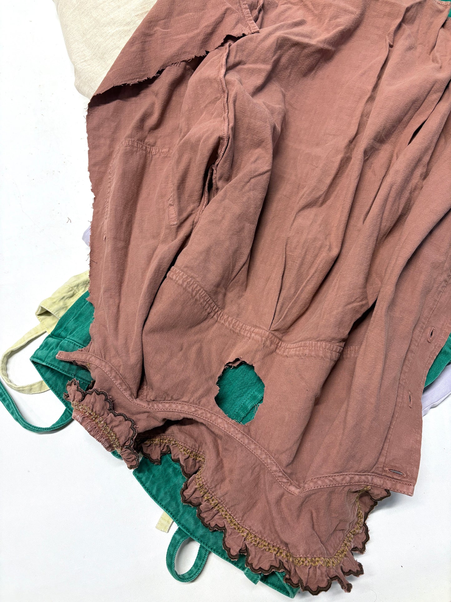 Brown ripped denim garment on top of green ripped denim garment