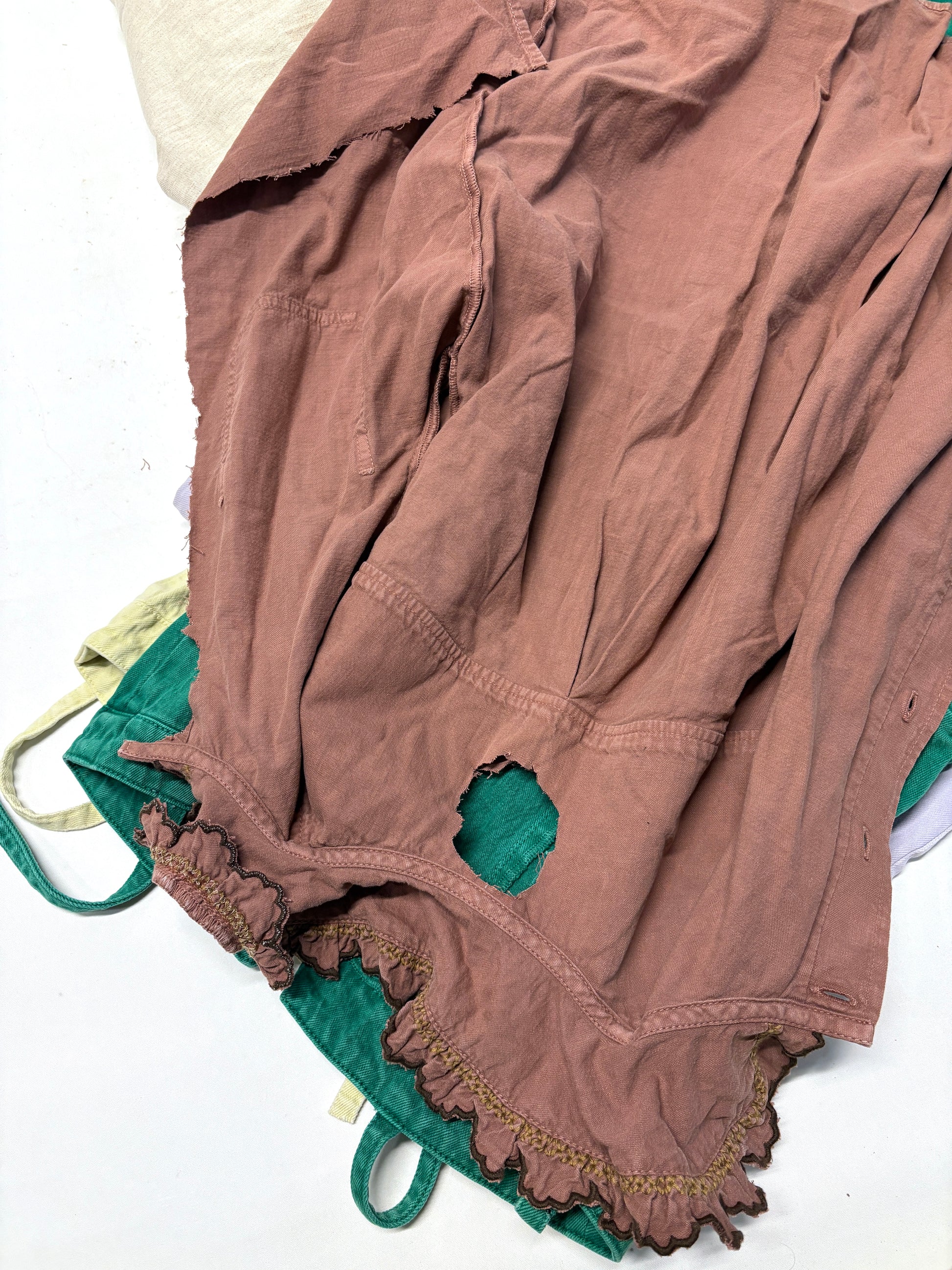 Brown ripped denim garment on top of green ripped denim garment