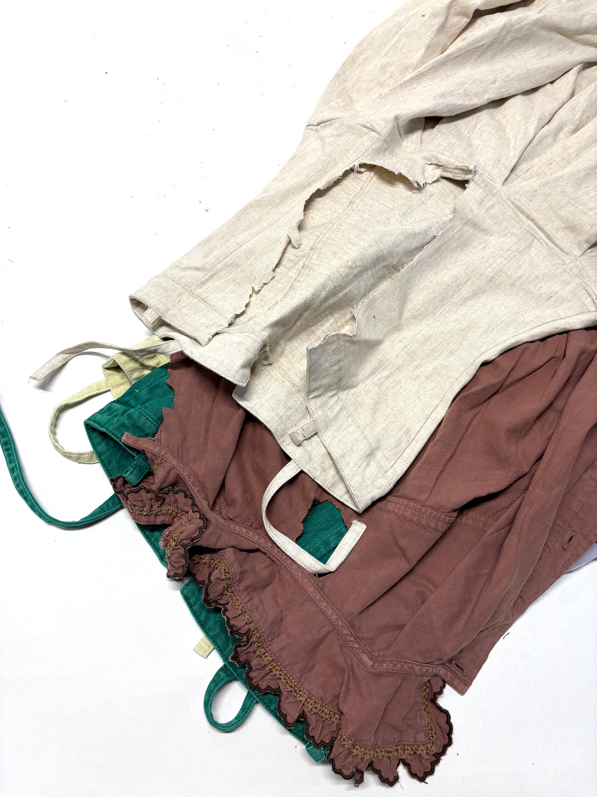 A stack of 4 different colours of ripped denim garments