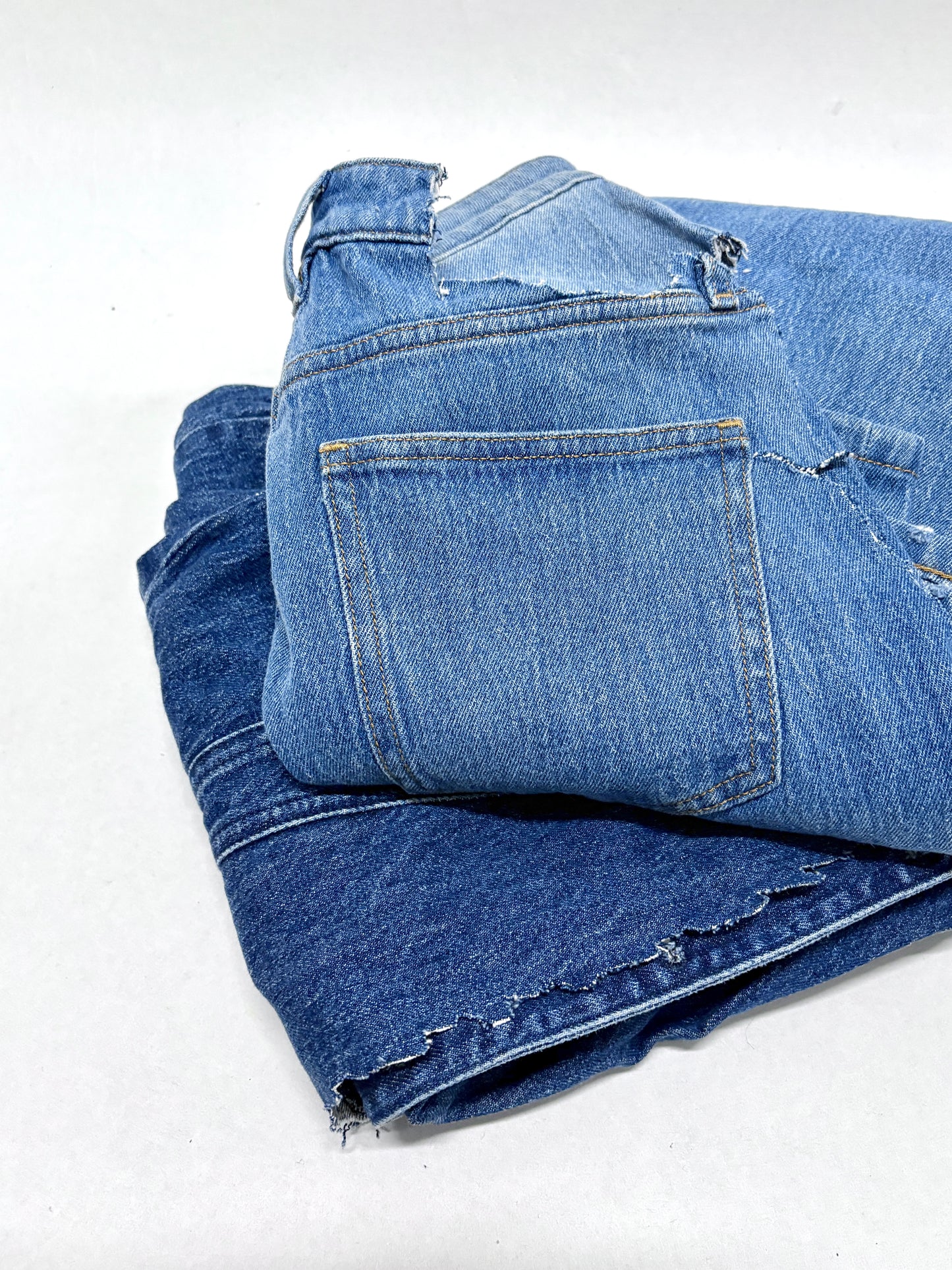 2 folded blue ripped denim garment 