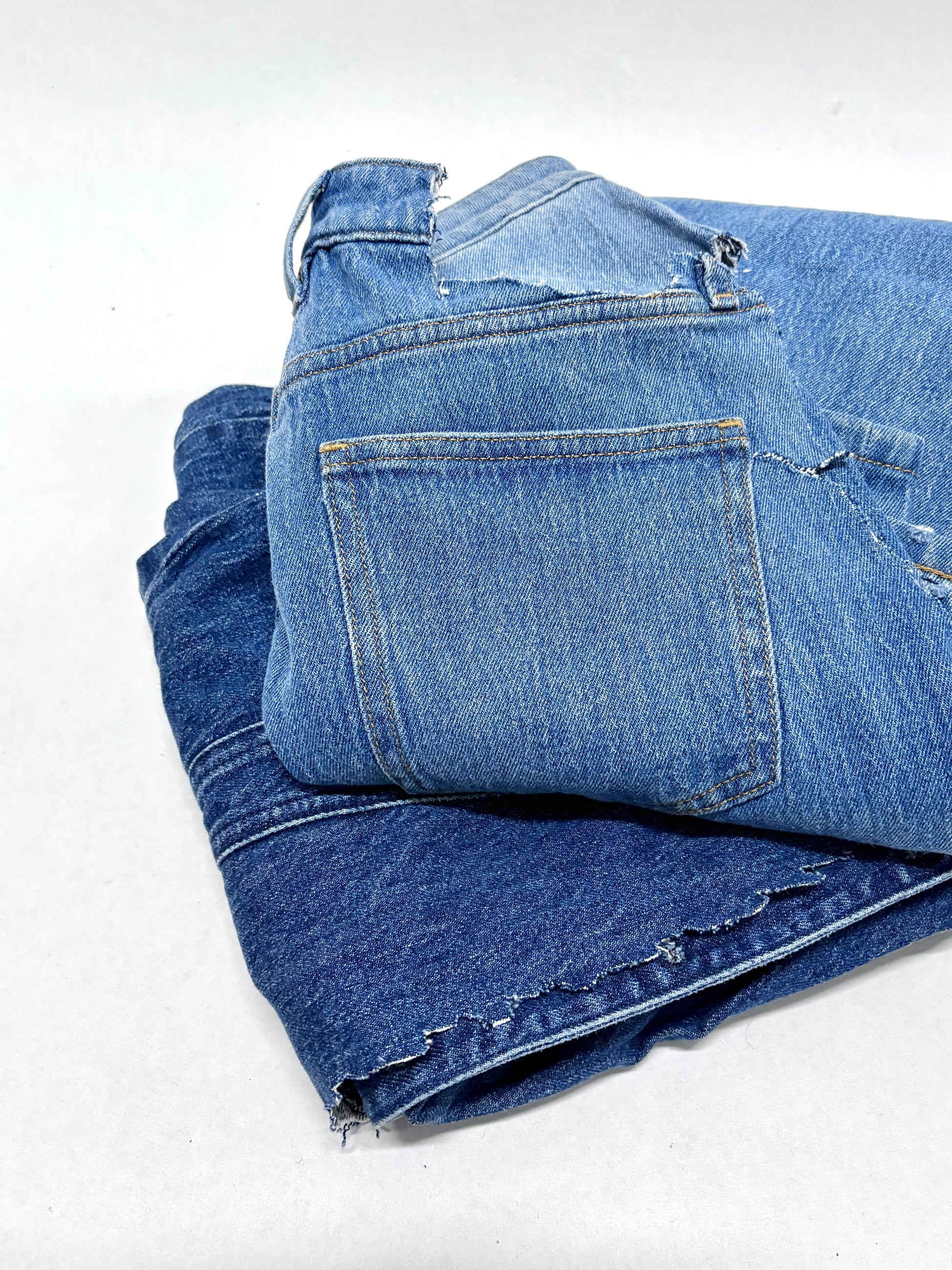 2 folded blue ripped denim garment 