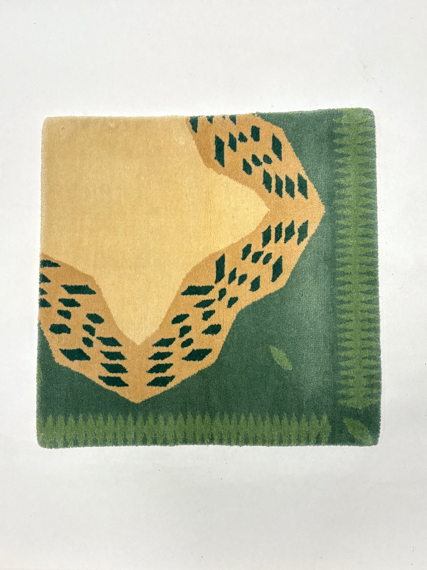 Green and beige coloured geometric patterned rug sample