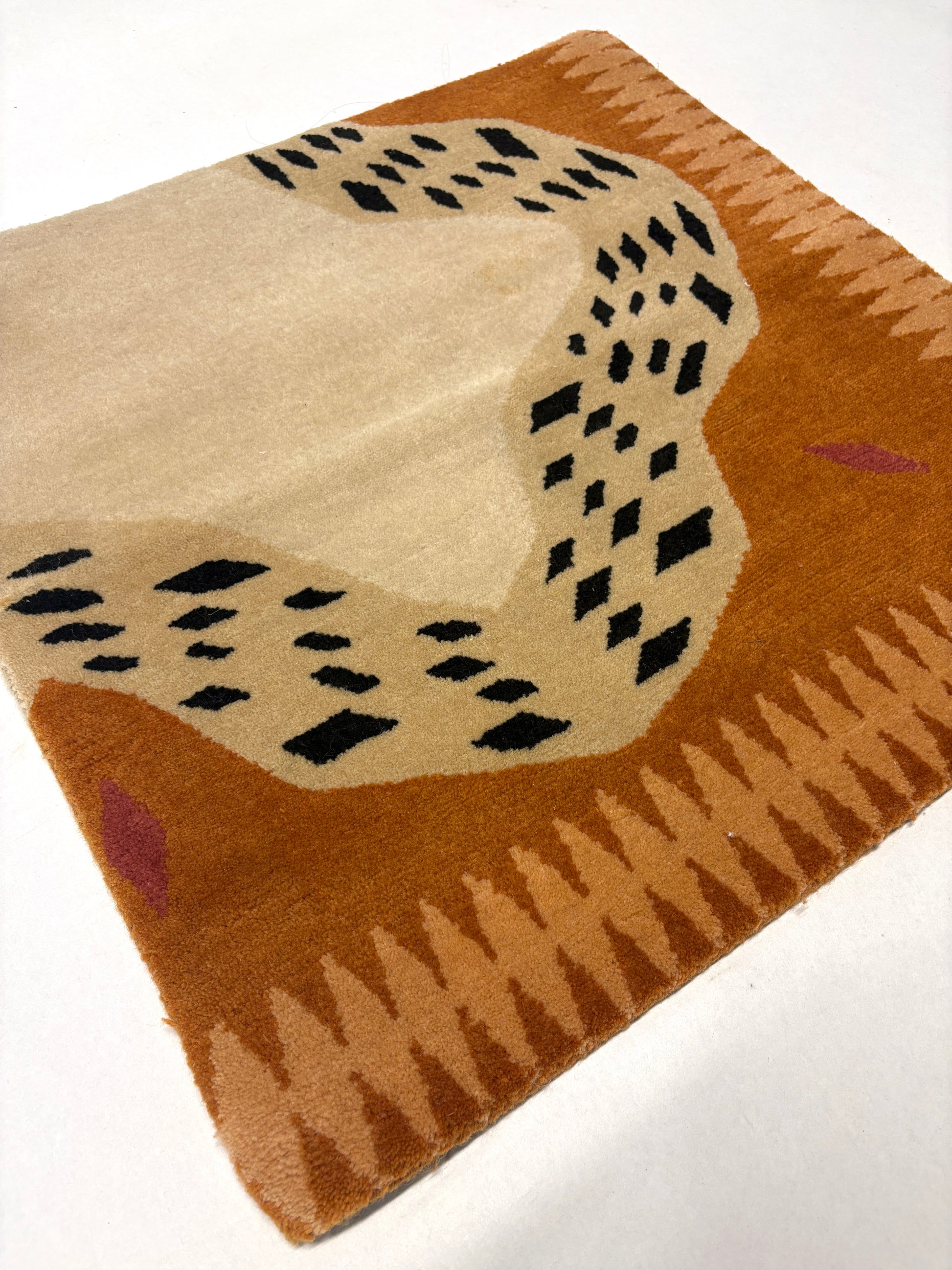 Brown, beige, and black coloured geometric patterned rug sample