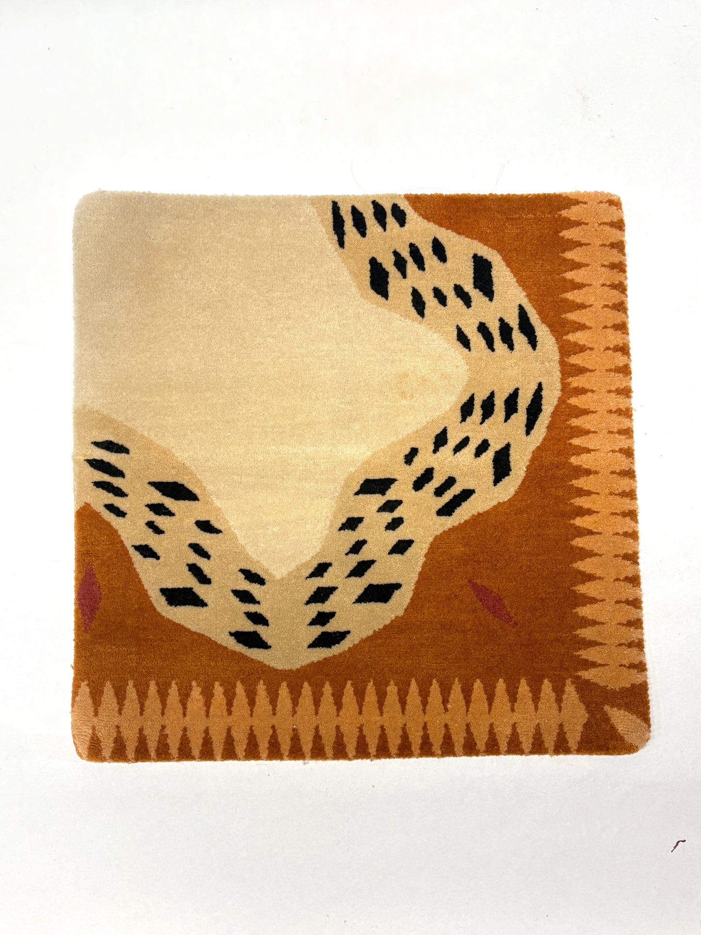 Brown, beige, and black coloured geometric patterned square rug sample