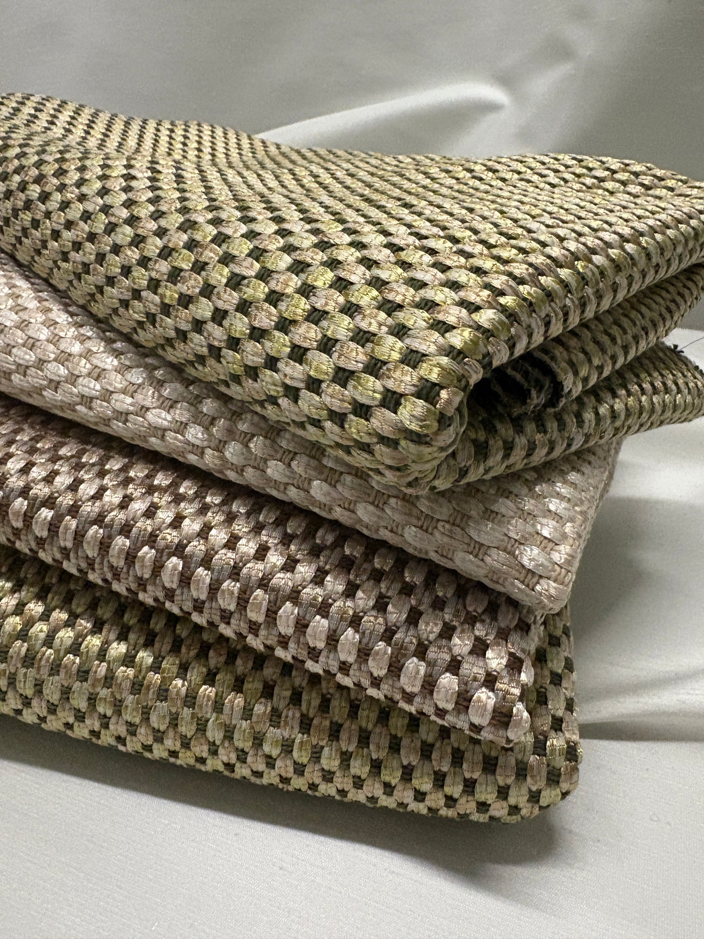 Close-up of stacked textured fabric swatches in muted neutral tones.