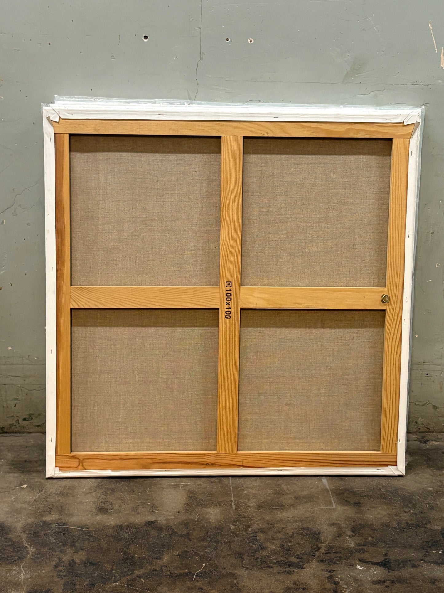A back of the square canvas, the wooden frame is cross-shaped.