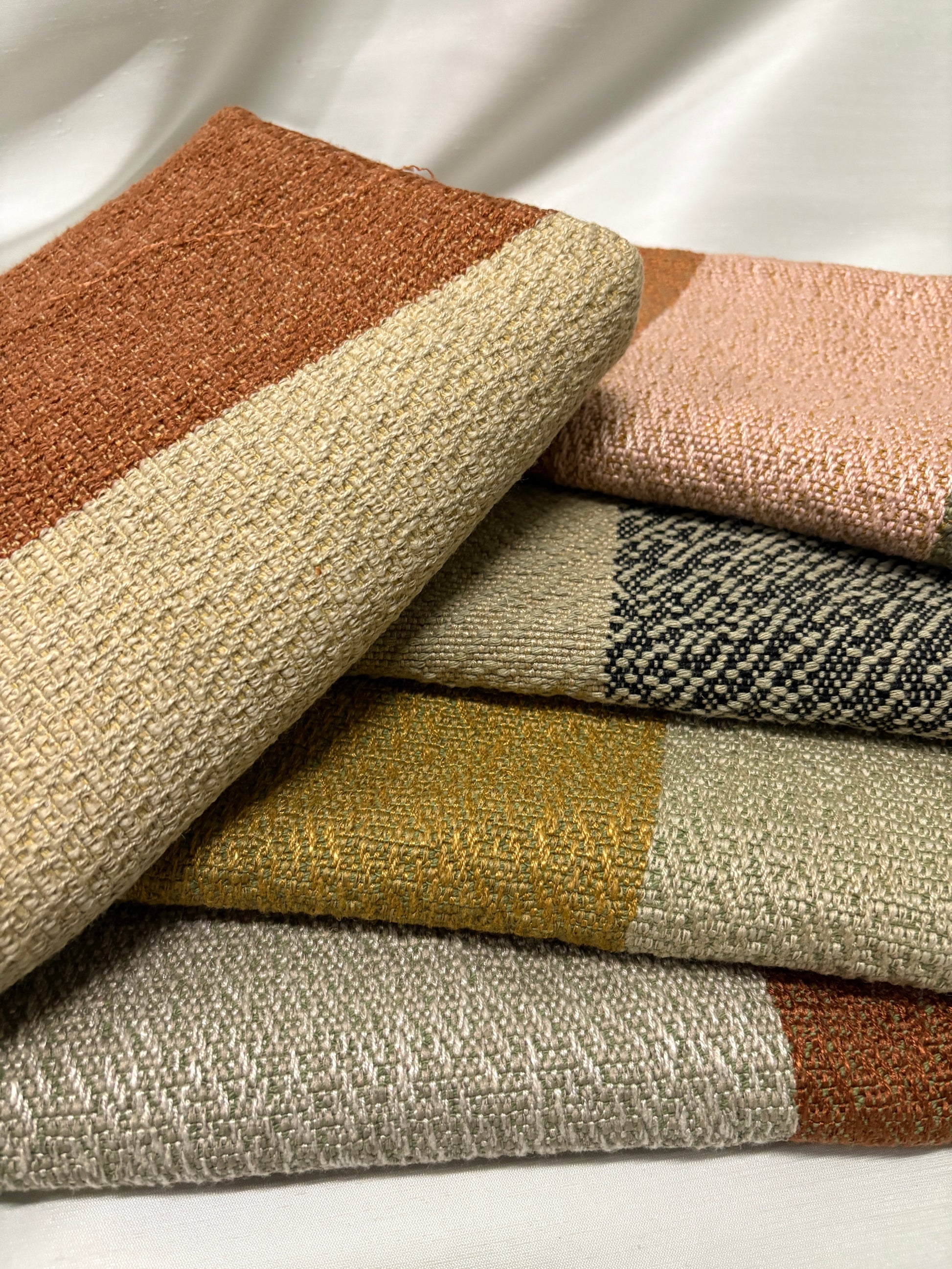Close-up of stacked colour-block fabric swatches in warm earthy tones.