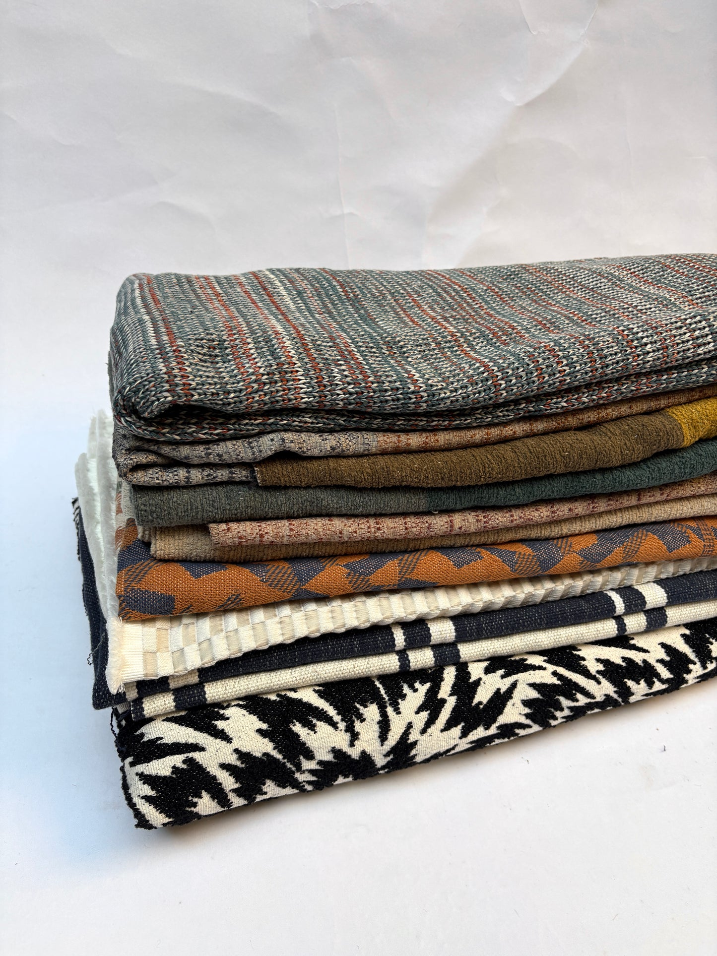 Close-up of stack of folded, textured variety of patterns fabric 