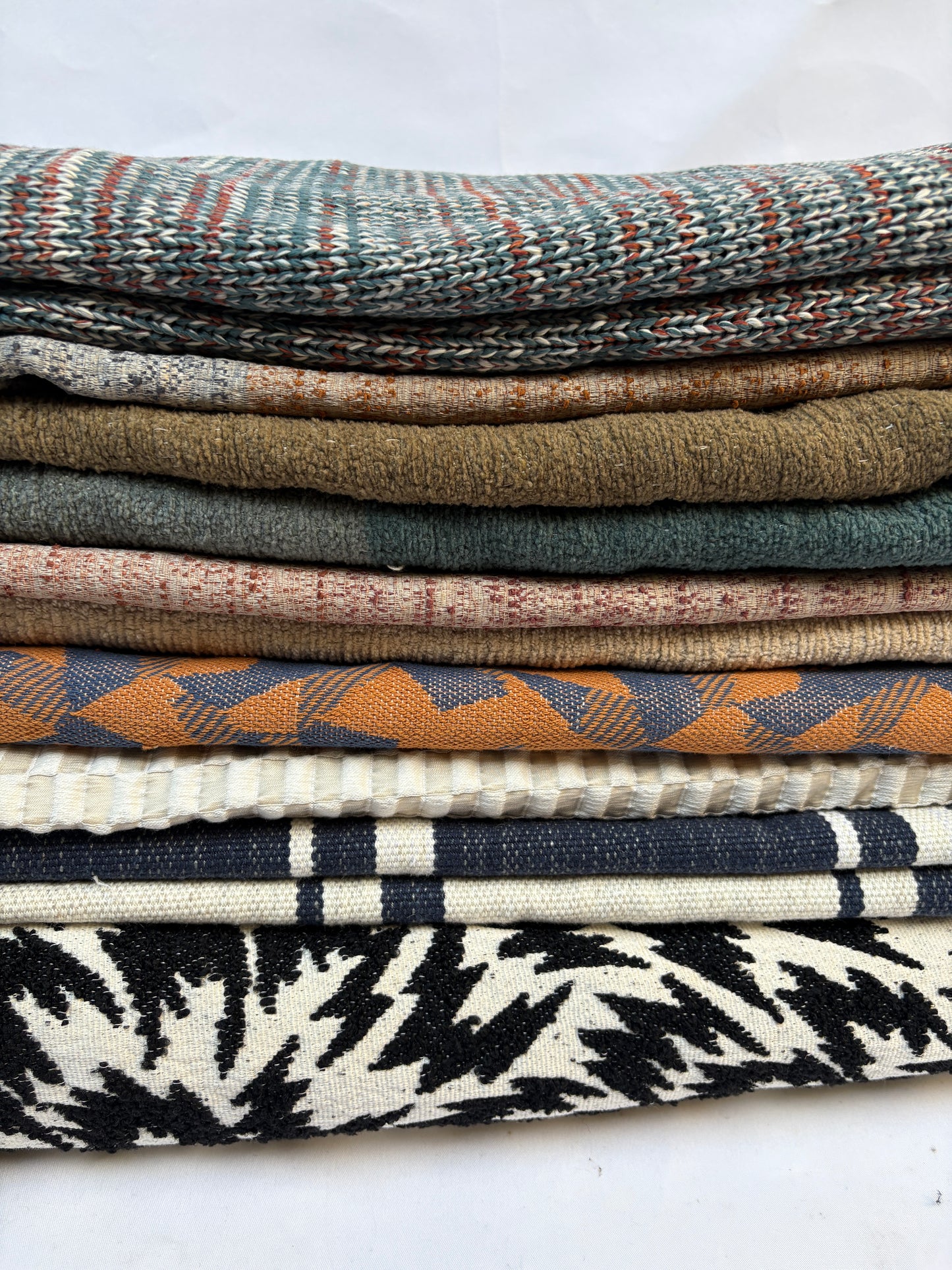 Stack of folded, textured variety of patterns fabric 