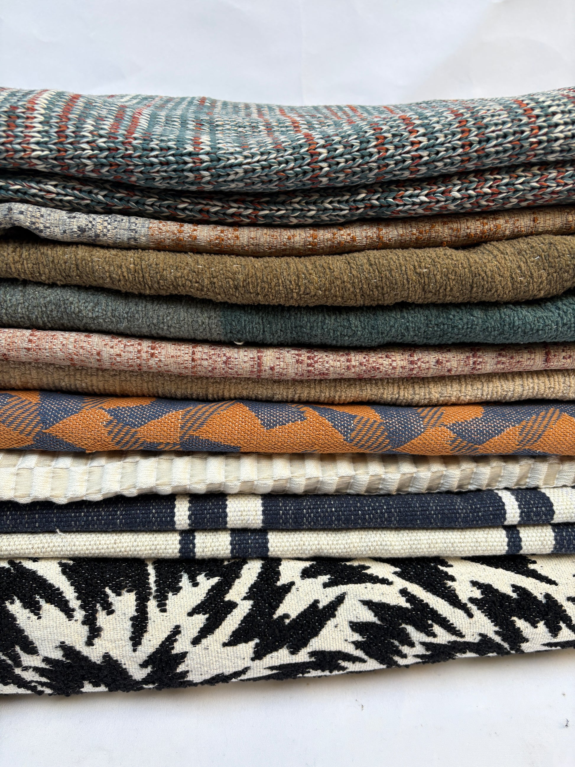 Stack of folded, textured variety of patterns fabric 