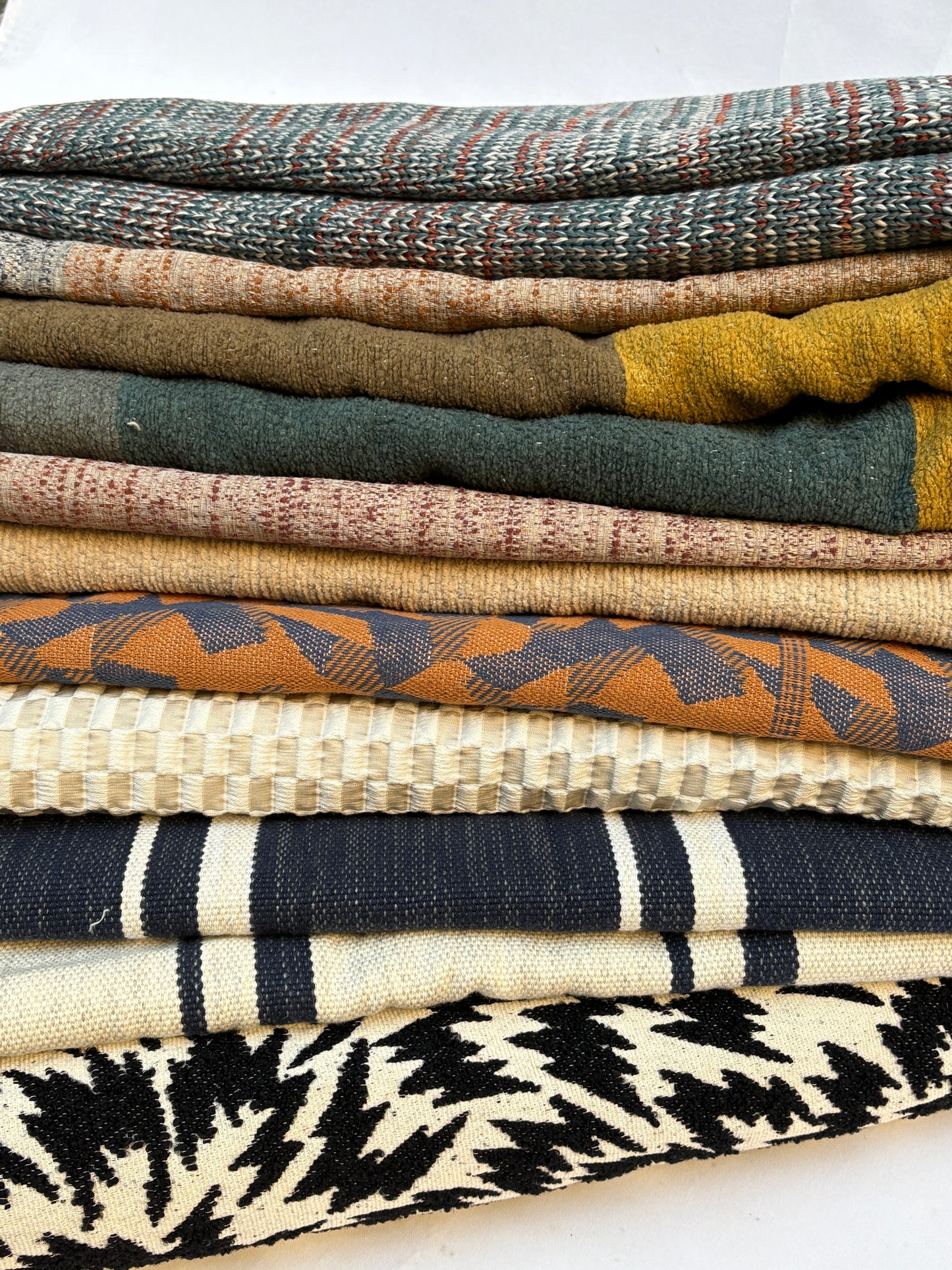Stack of folded, textured variety of patterns fabric 