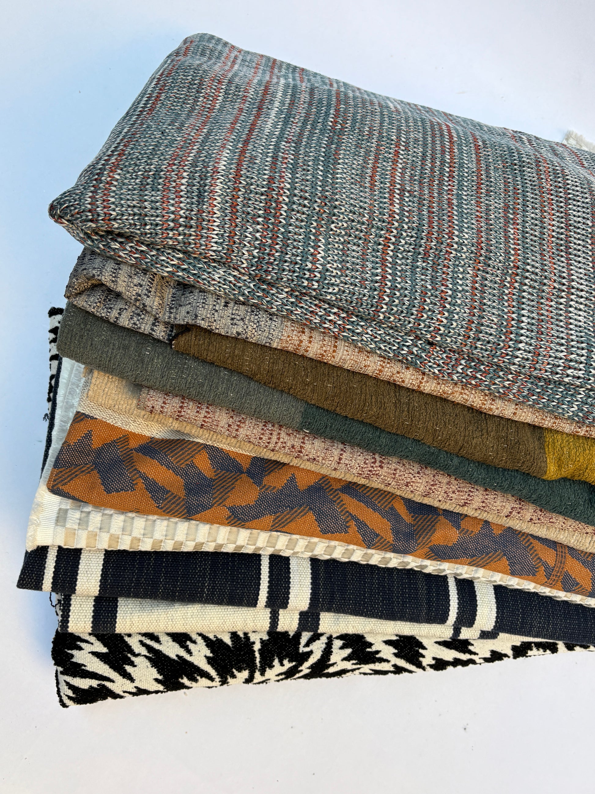 Stack of folded, textured variety of patterns fabric 