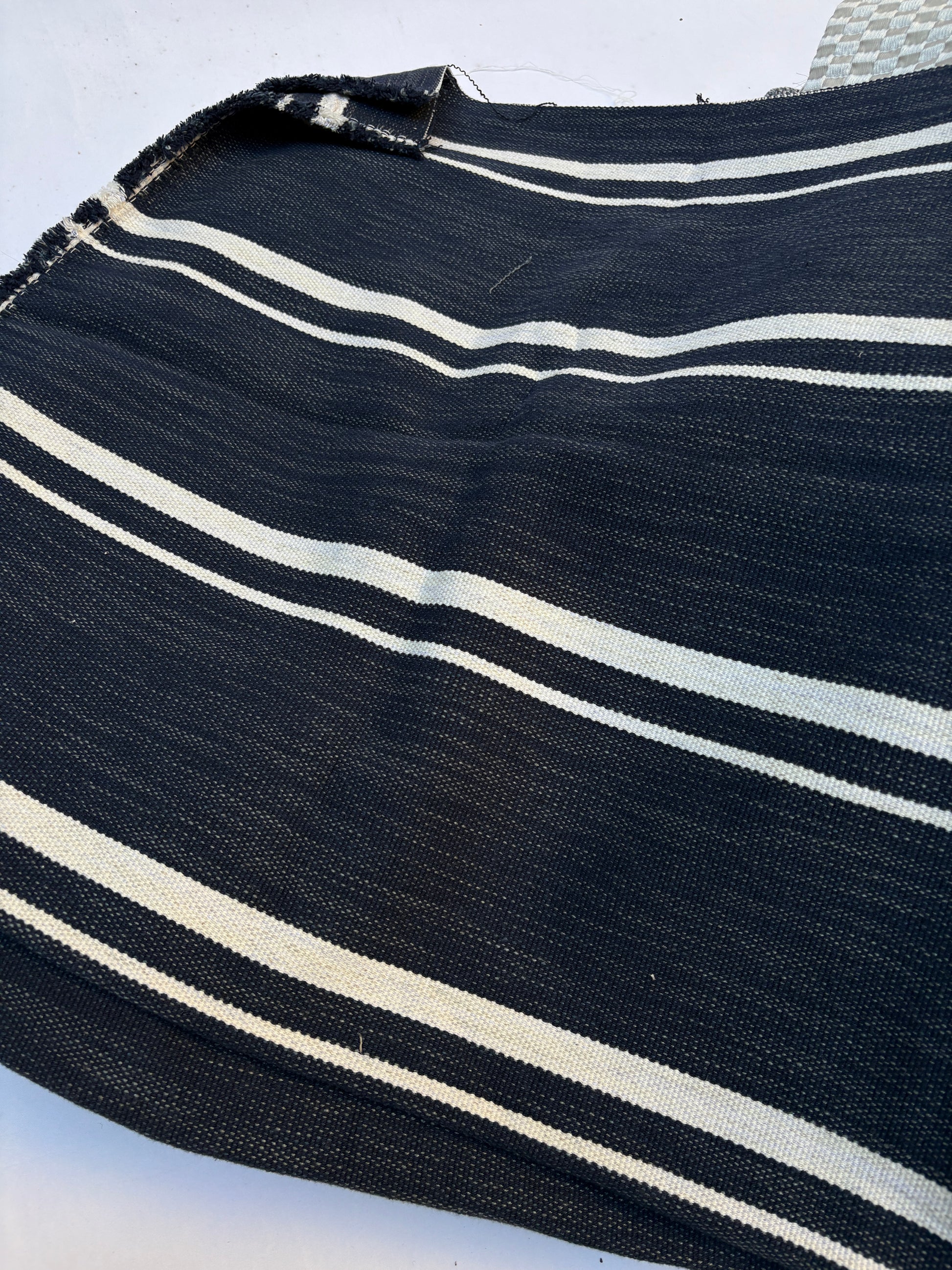 Close-up of textured fabric with white stripes on a navy blue 