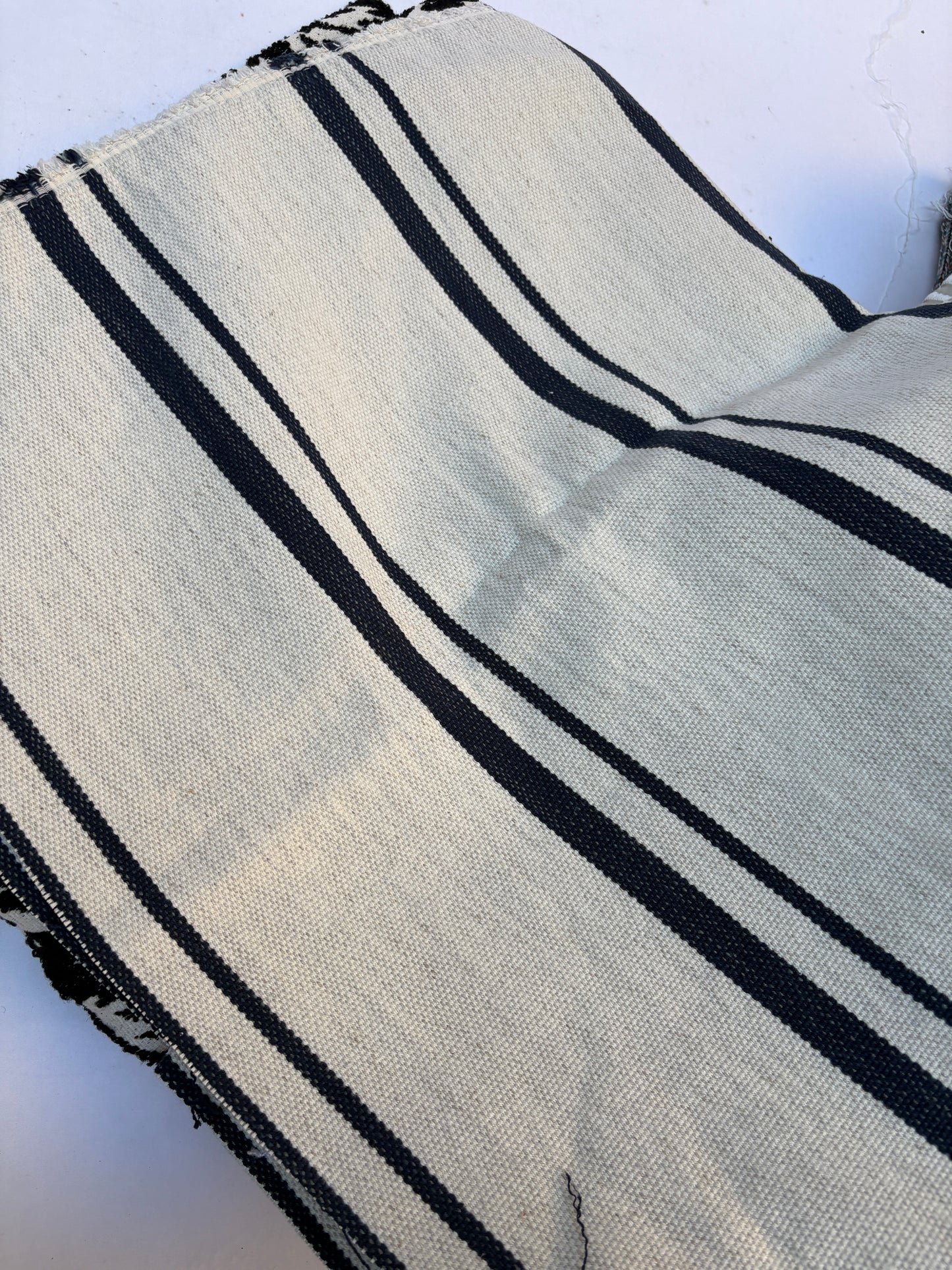 Close-up of textured fabric with navy blue stripes on white
