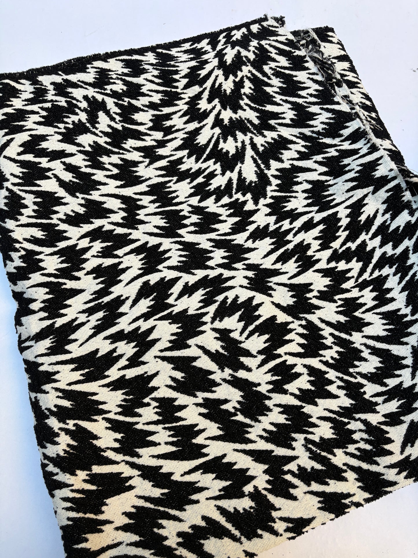 Textured fabric with a black zigzag pattern on a white base