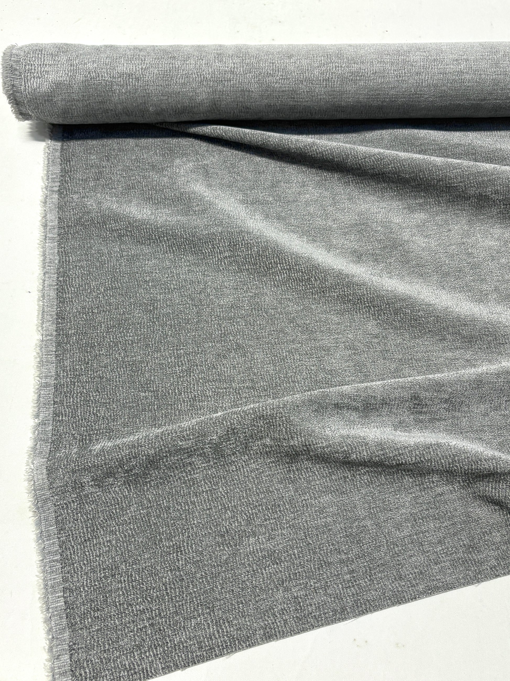 Rolled gray textured weave velvet fabric, partially unfolded 