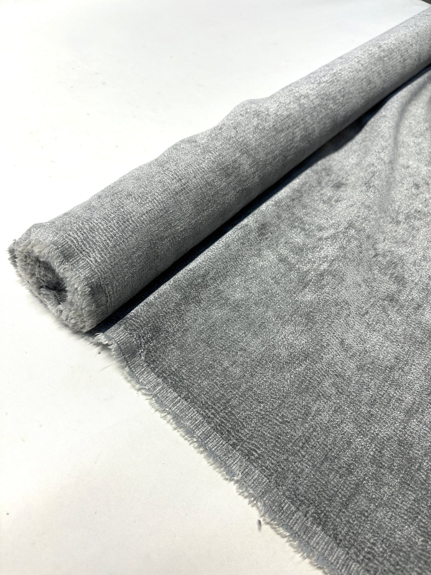 Close-up of rolled grey textured weave velvet fabric from its edge