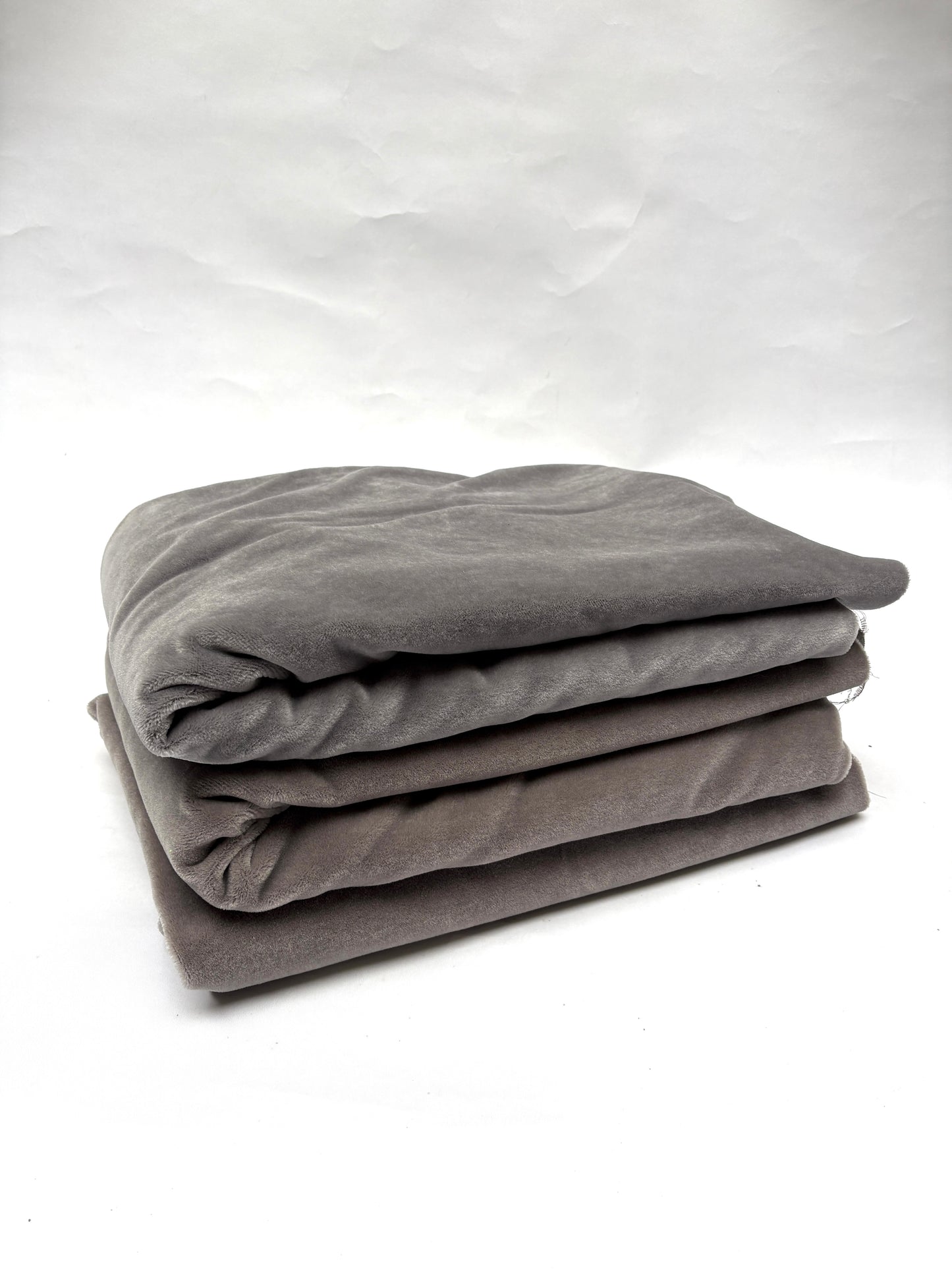 Stack of folded gray blankets and brown blankets 