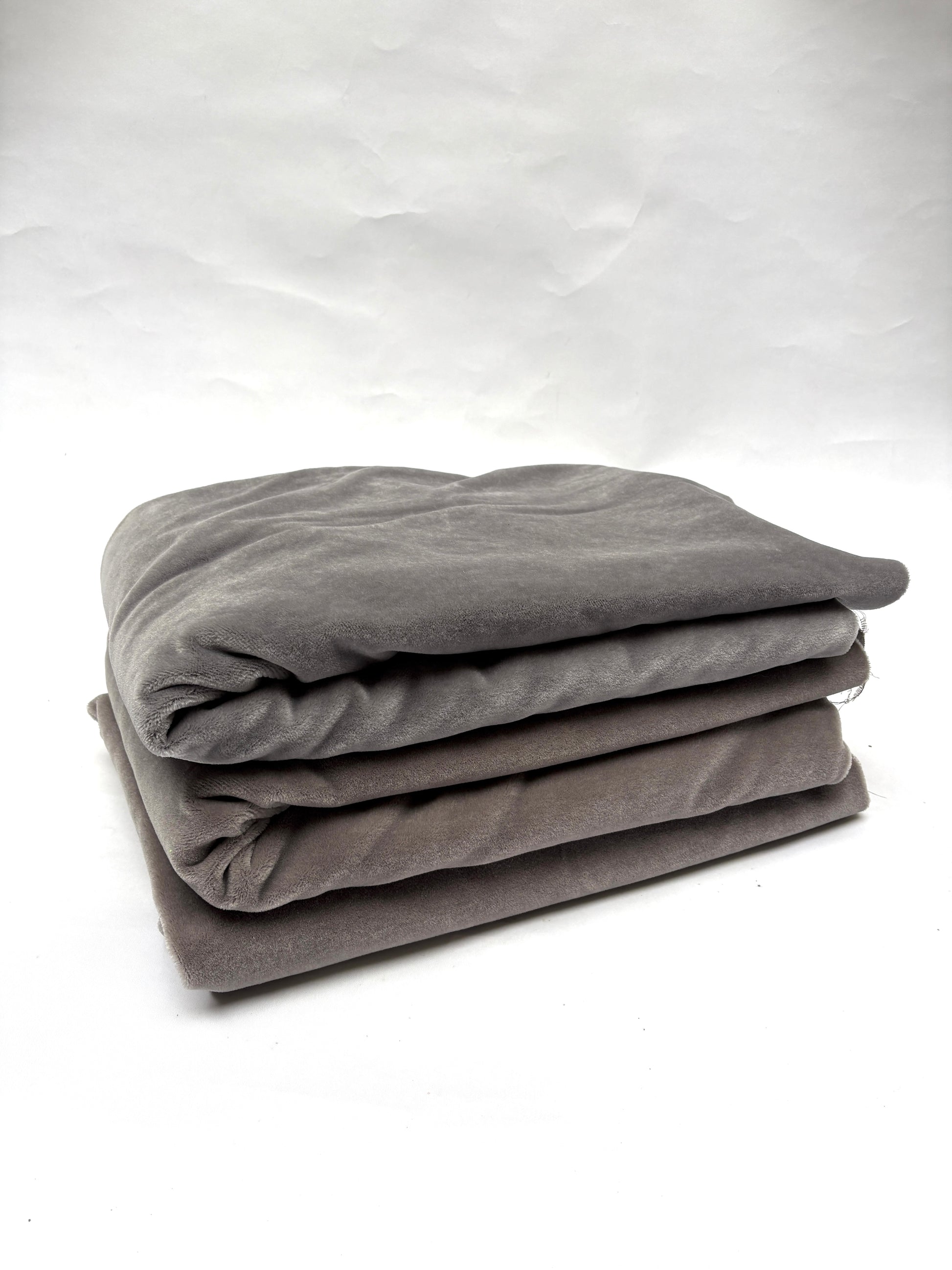 Stack of folded gray blankets and brown blankets 