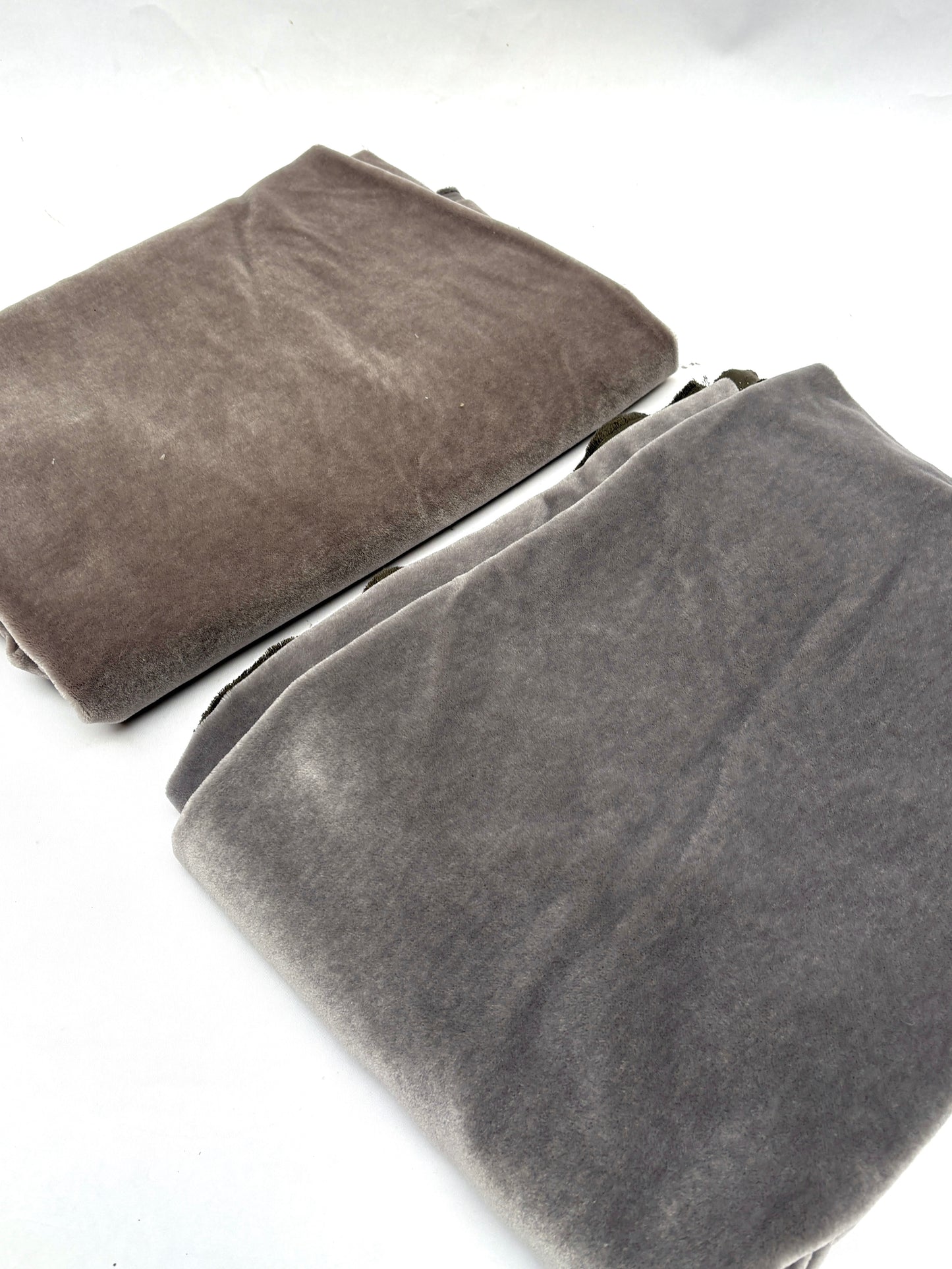 A grey blanket and a brown blanket, folded and placed side by side