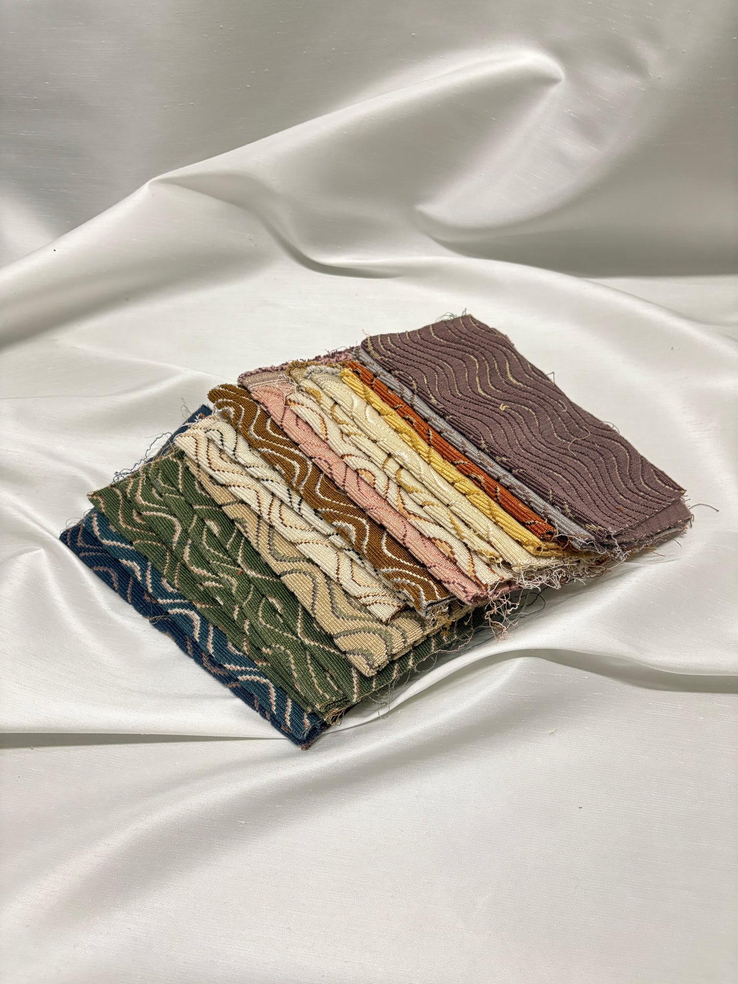Detailed view of stacked patterned fabric swatches in mixed woven textures.