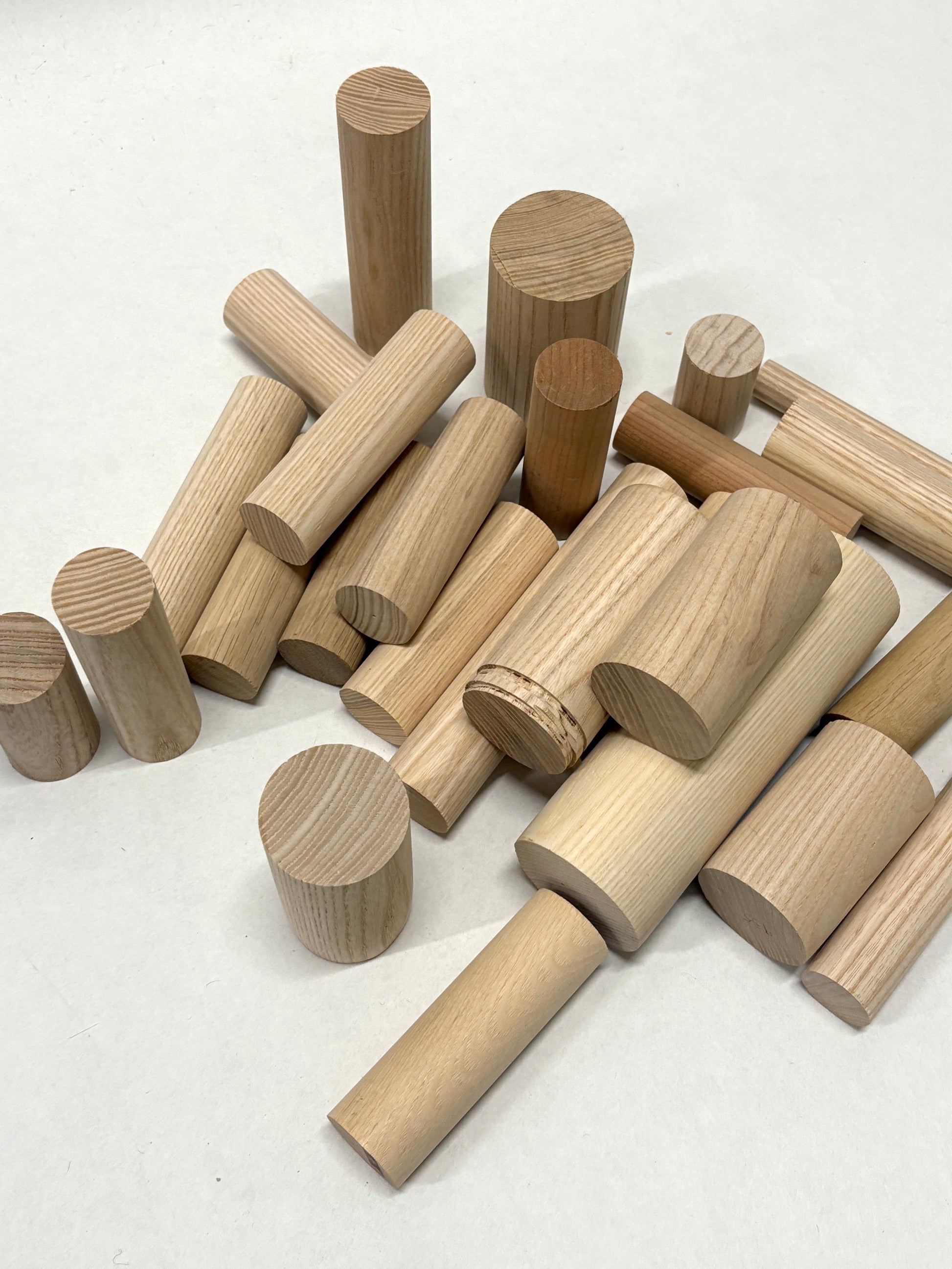 Mixed wooden dowels and round wooden pieces displayed together.