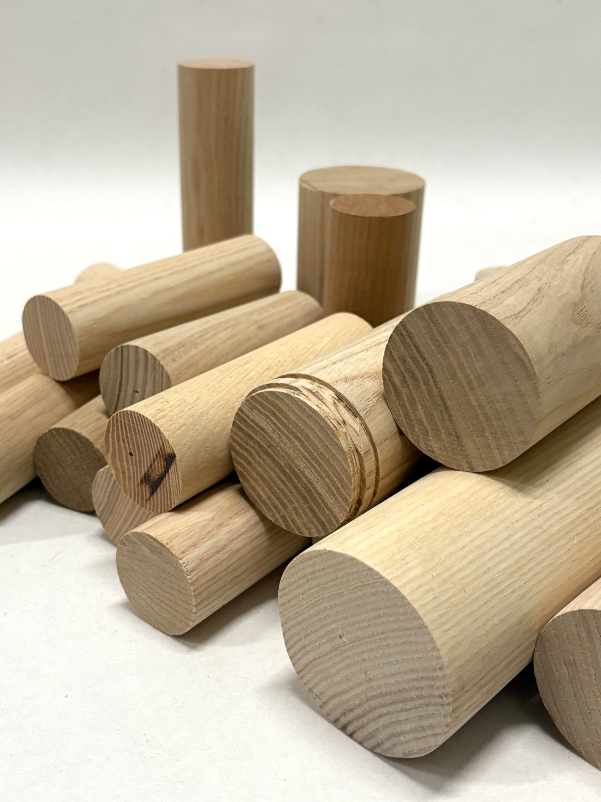 Grouped wooden rods and cylinder forms arranged in a loose composition.
