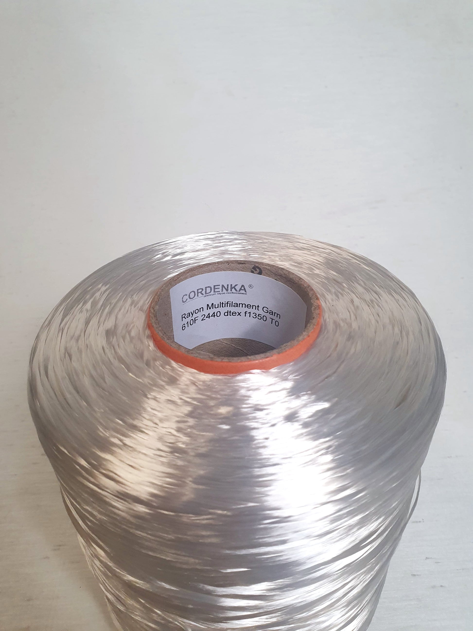 Close up of a cone of rayon multifilament garn with 610F, 2440 dtex, f1350 TO.  