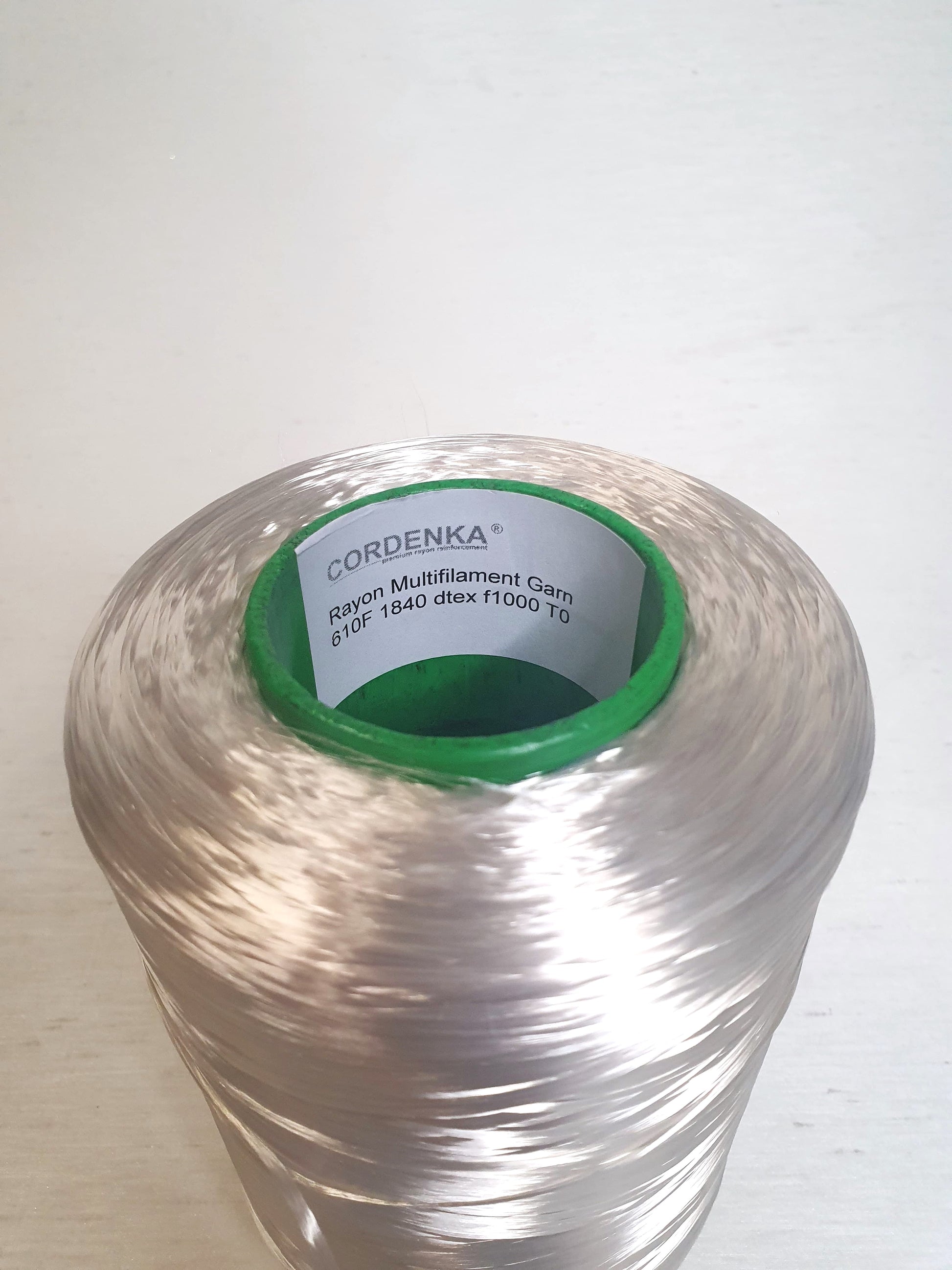 Close up of a cone of rayon multifilament garn with 610F, 1840 dtex, f1000 TO.  
